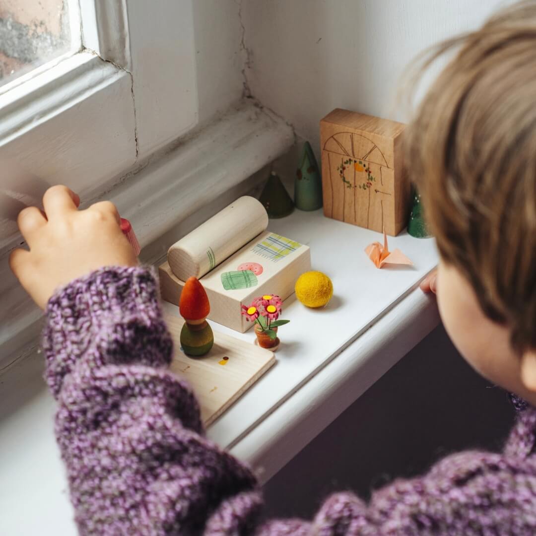 A child playing with pieces from the Grapat 2026 Advent Calendar.