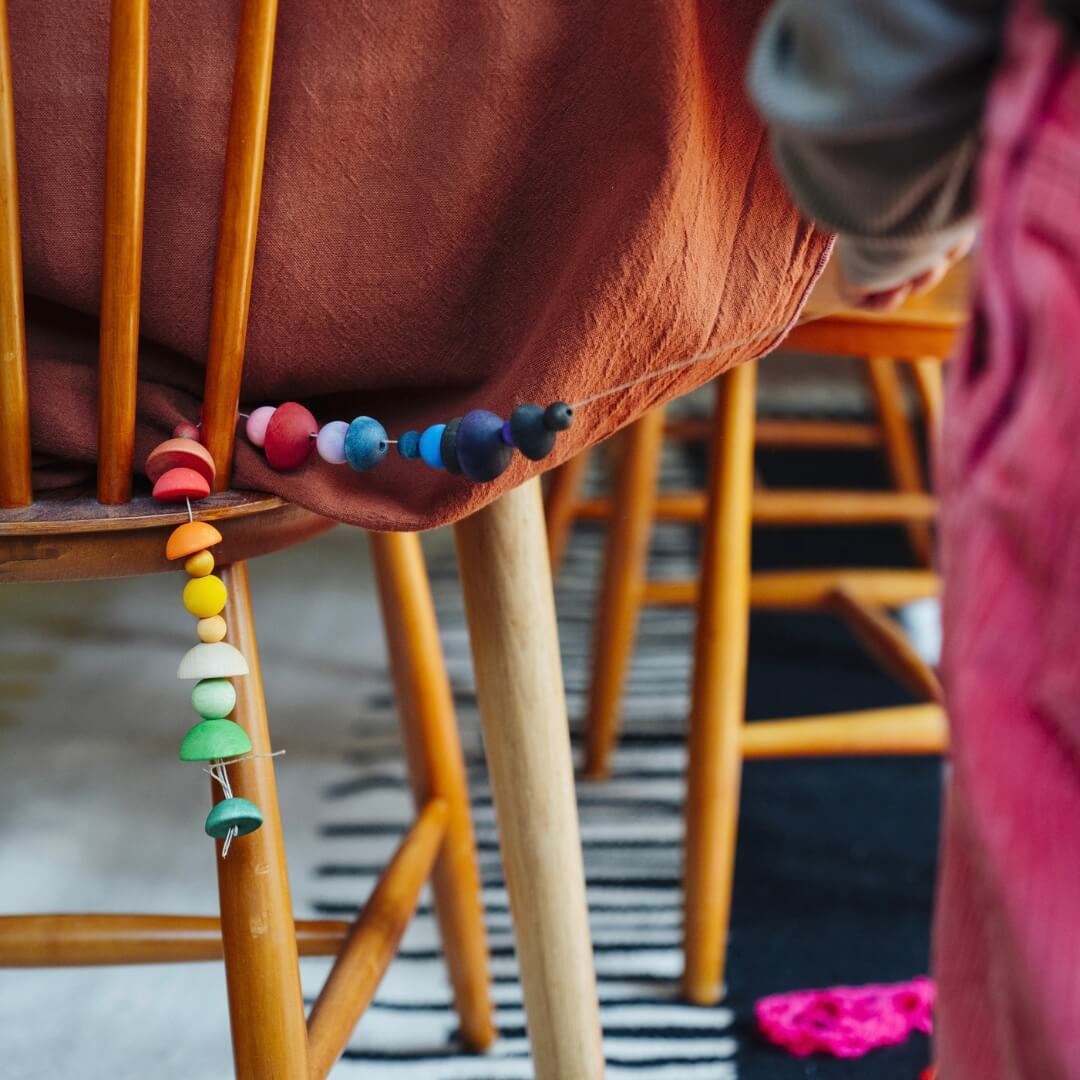 A child decorates with a colorful rainbow garland made with peices from the Grapat 2026 Advent Calendar.